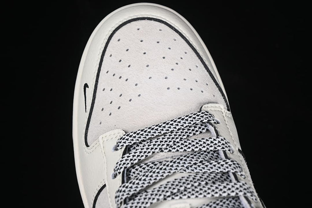 Top view of the perforated light-colored toe and patterned laces