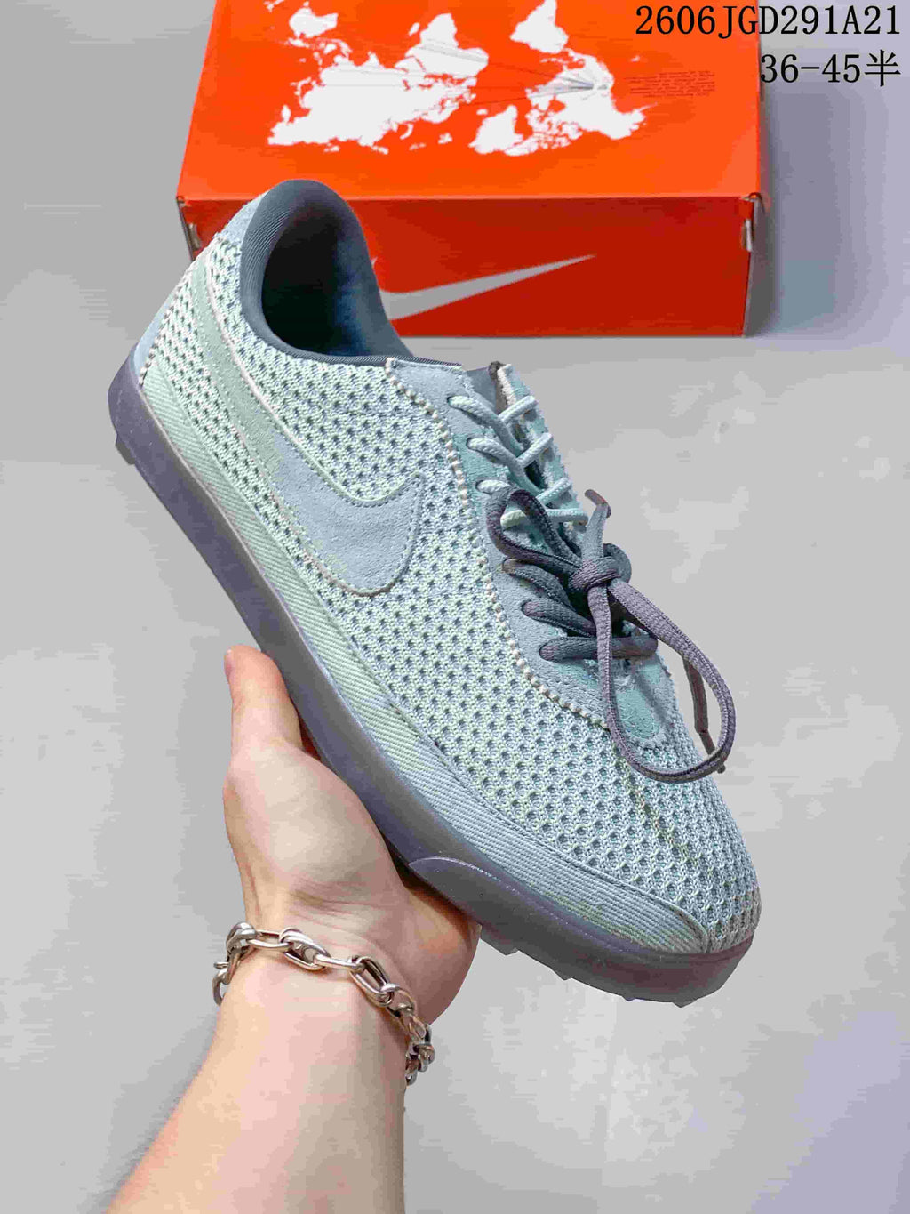 Side view of a pale blue-gray Nike sneaker with a darker Swoosh and outsole.