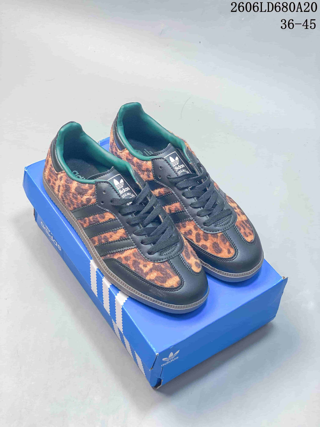 Pair of leopard-print adidas Samba OG low-top sneakers with dark overlays and gum-tone soles