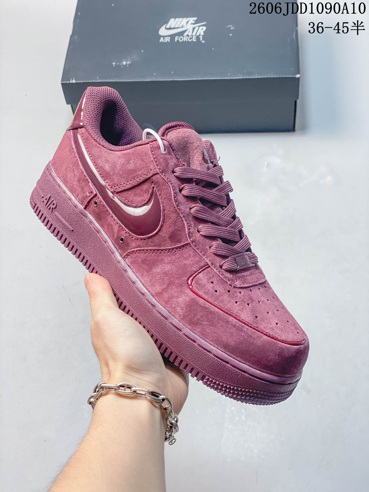 Mauve Nike Air Force 1 low-top sneaker with lace-up front, perforated toe, and side Swoosh.