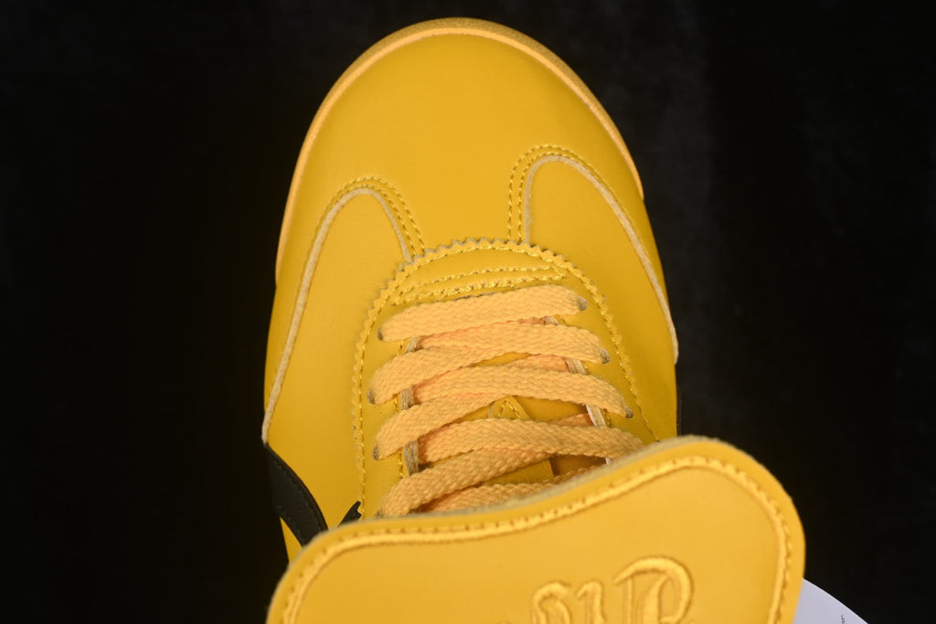 Close-up of the yellow toe box, stitched panels, and lace area
