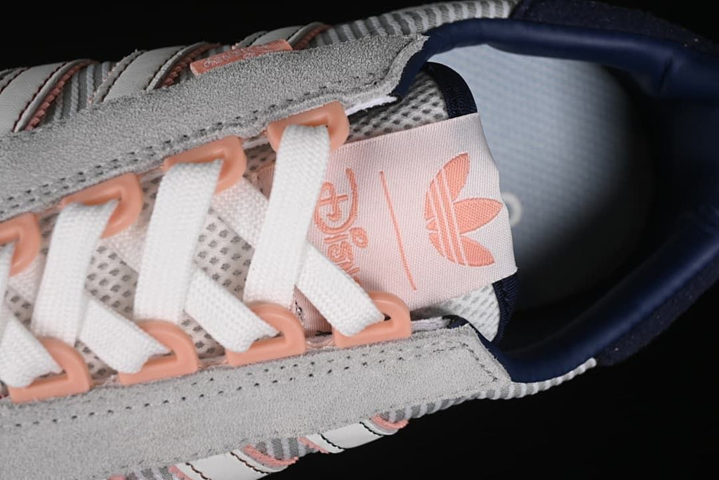 Close-up of white laces, pink lace loops, and tongue branding