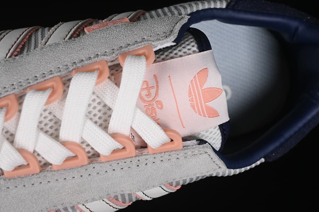 Close-up of white laces, pink lace loops, and tongue branding