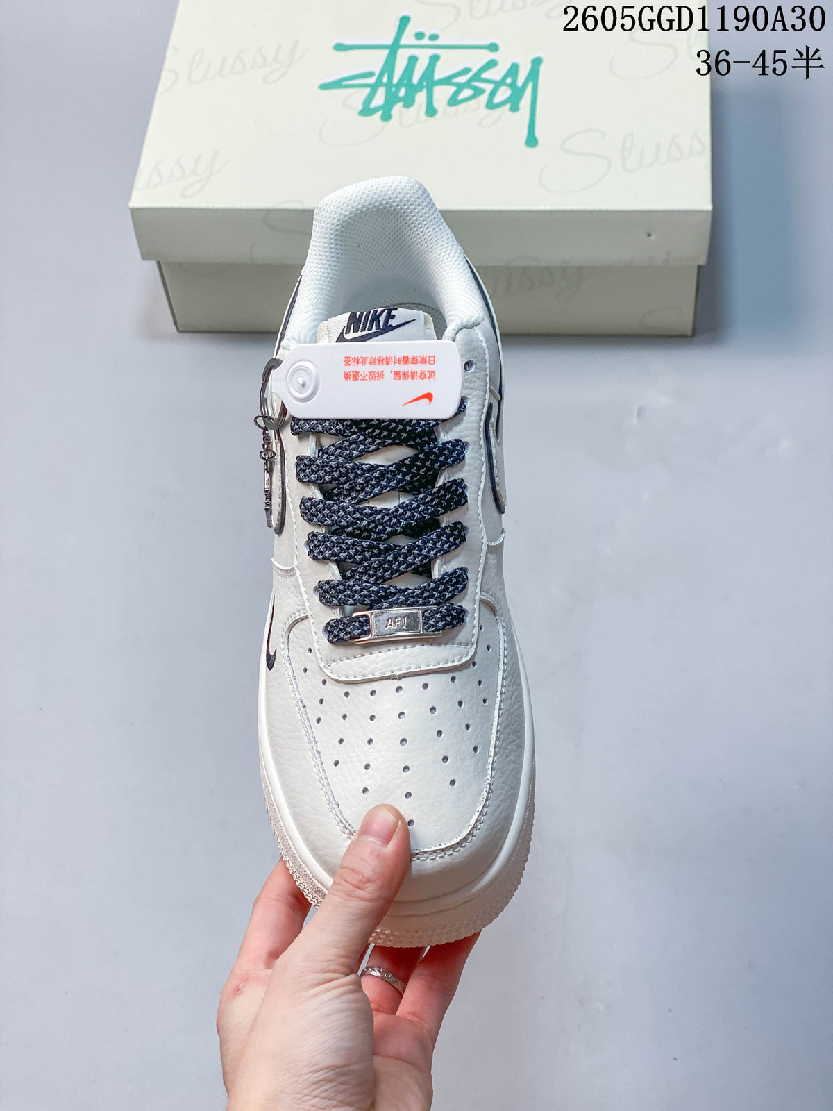 Top view of a white sneaker showing perforated toe, patterned laces and lace tag