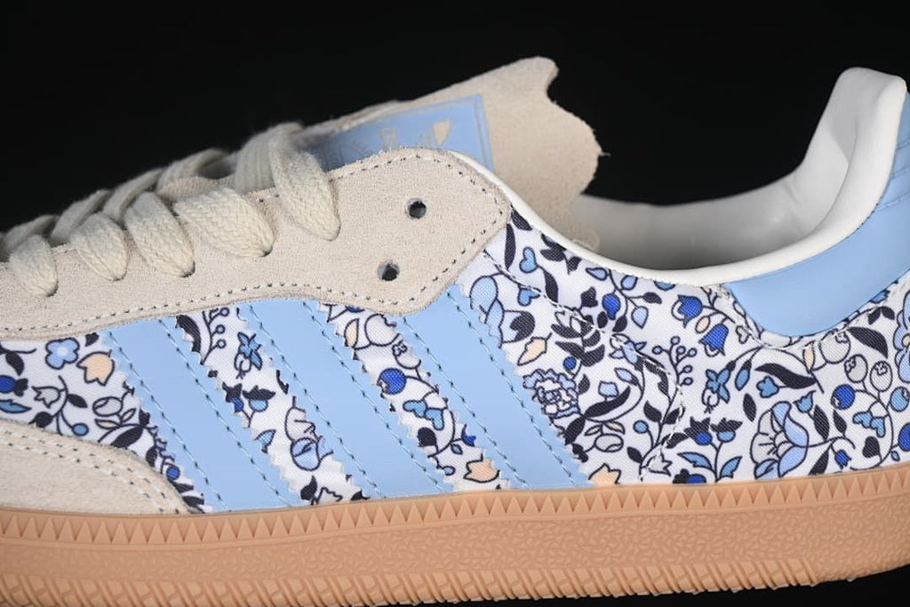 Close-up of the floral-print side panel, light blue stripes, cream overlay, and gum sole