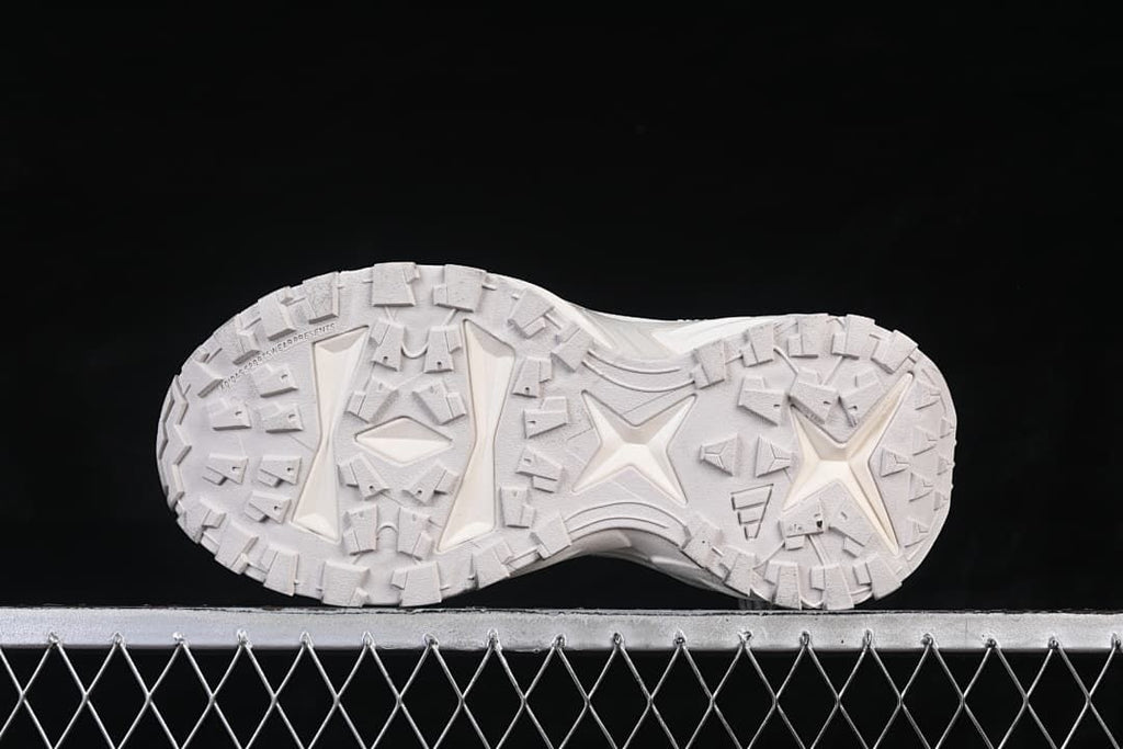 Underside view of the sneaker with its geometric tread pattern.