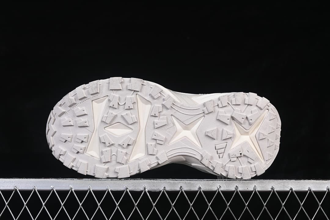 Underside view of the sneaker with its geometric tread pattern.