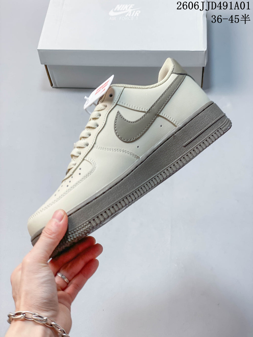 Side view of a cream low-top sneaker with taupe Swoosh and sole