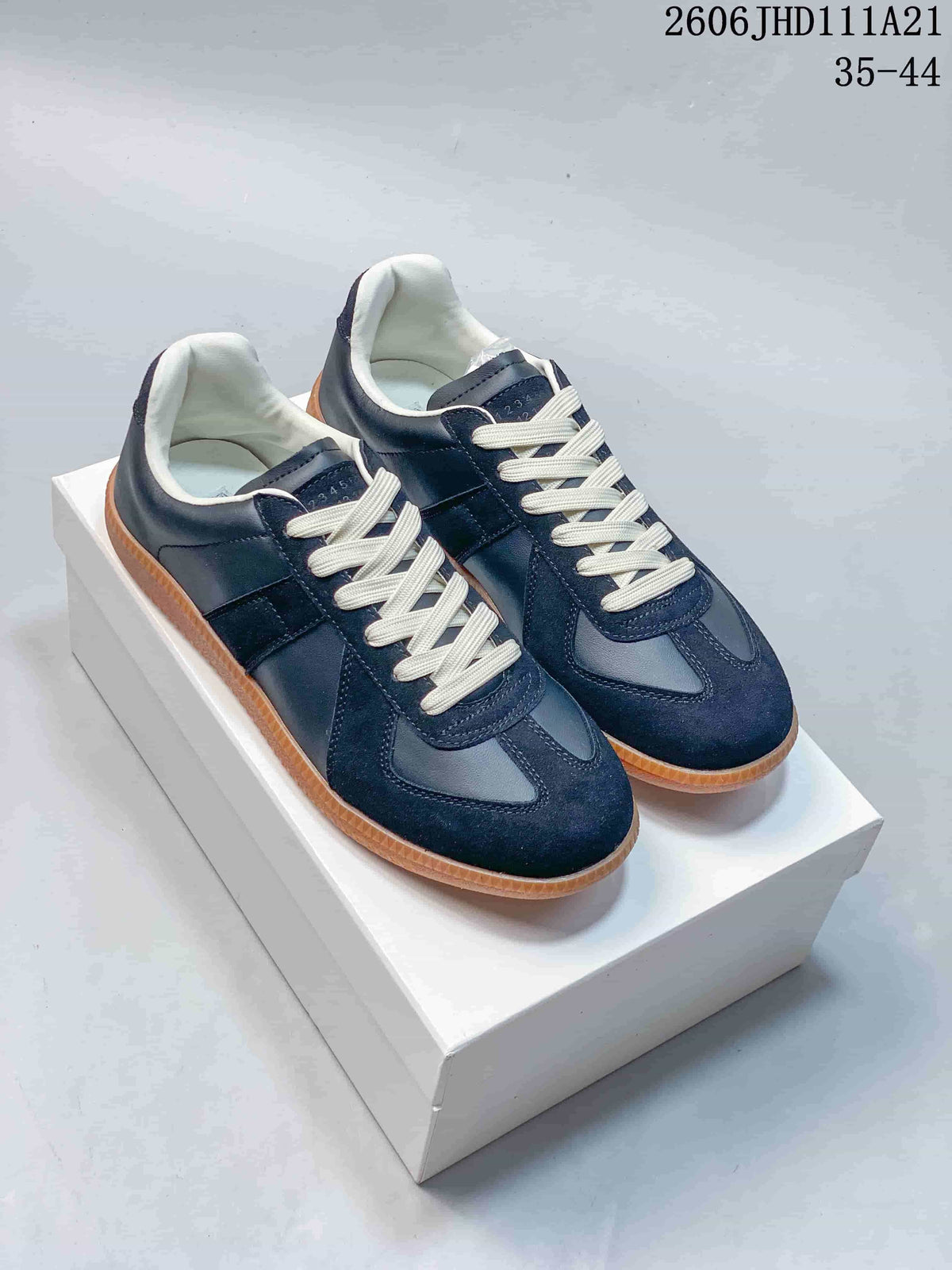 Pair of navy low-top sneakers with cream laces and gum-colored soles