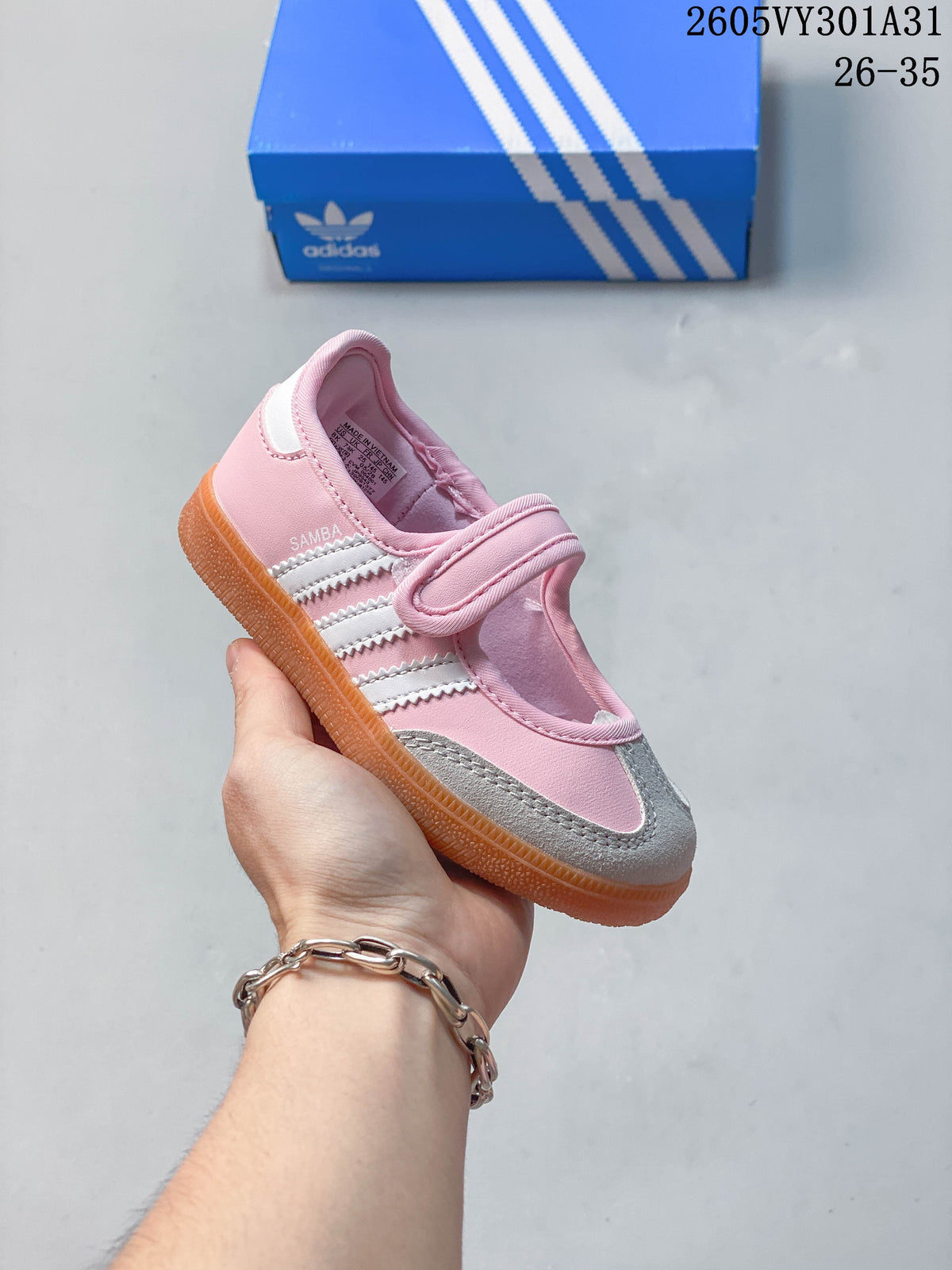 Pink kids’ Samba Jane shoe with white side stripes and gray toe detail