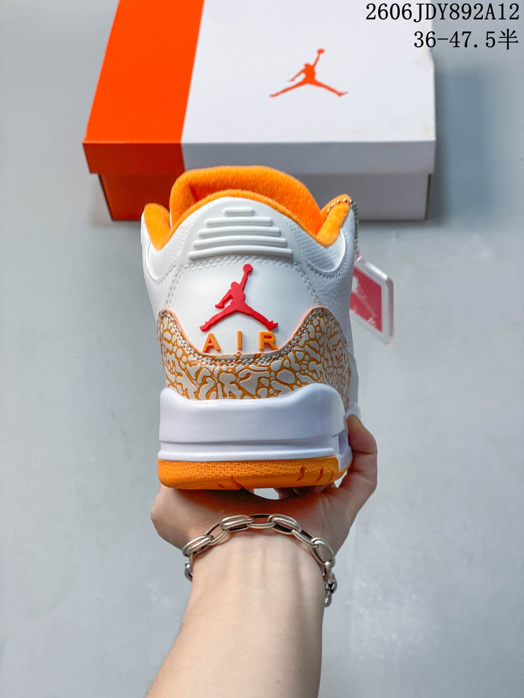 Rear view highlighting the patterned heel overlay and orange accents.
