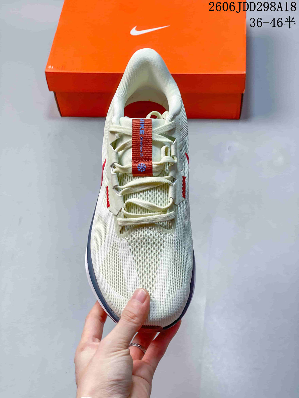 Top view of the cream mesh running shoe with cream laces and red tongue detail
