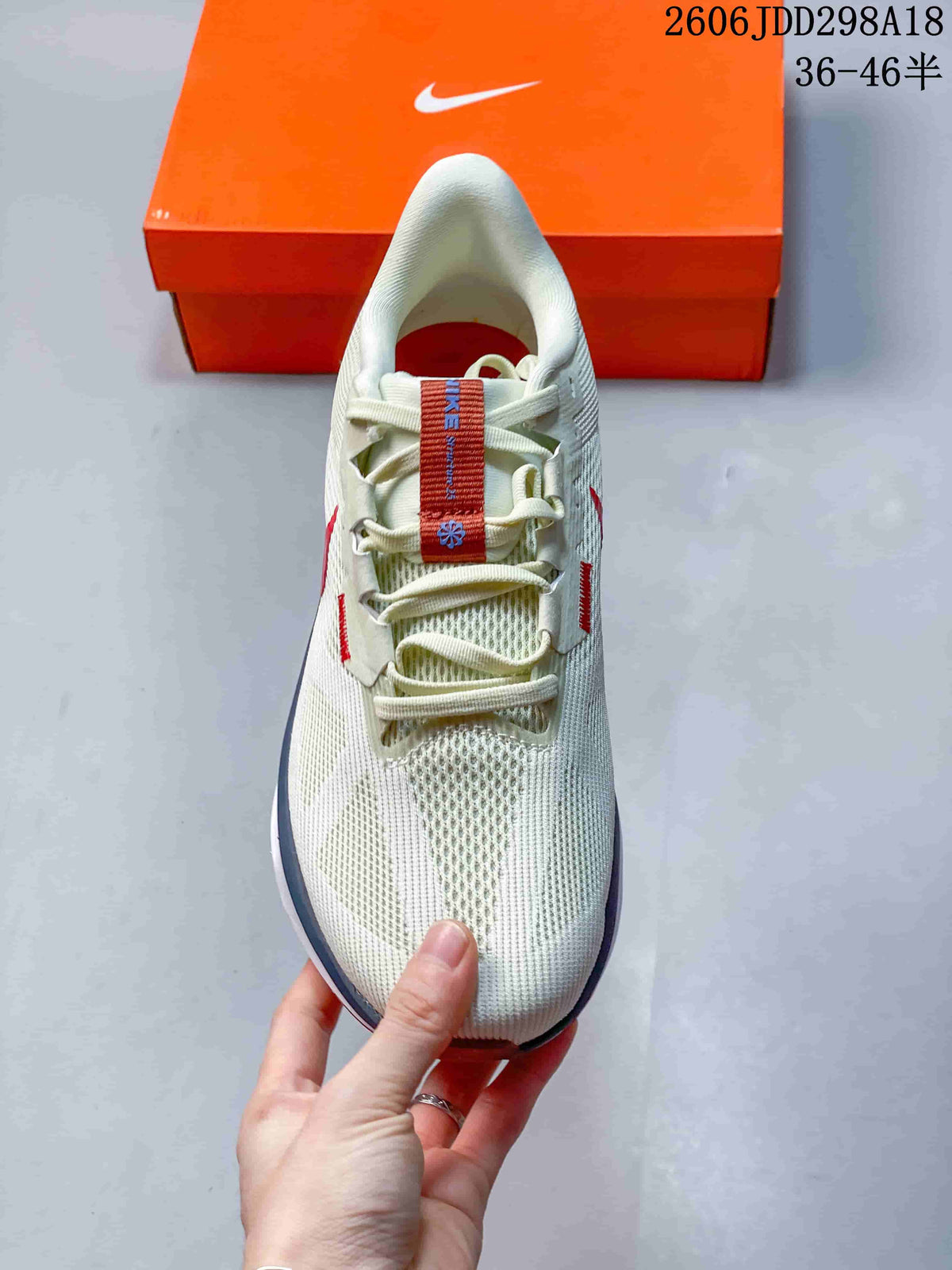 Top view of the cream mesh running shoe with cream laces and red tongue detail