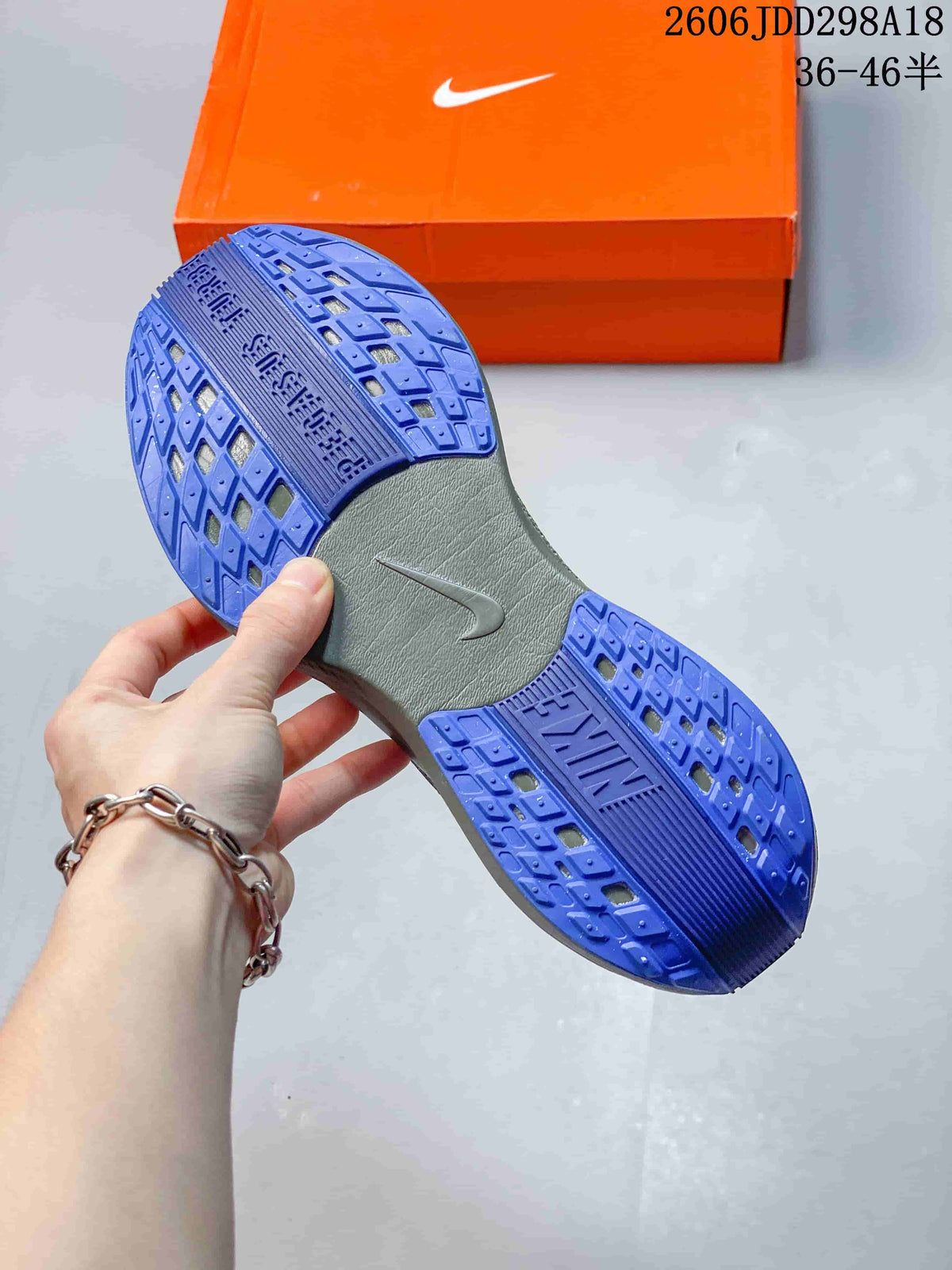 Close-up of the blue patterned outsole and gray midfoot section of a Nike running shoe