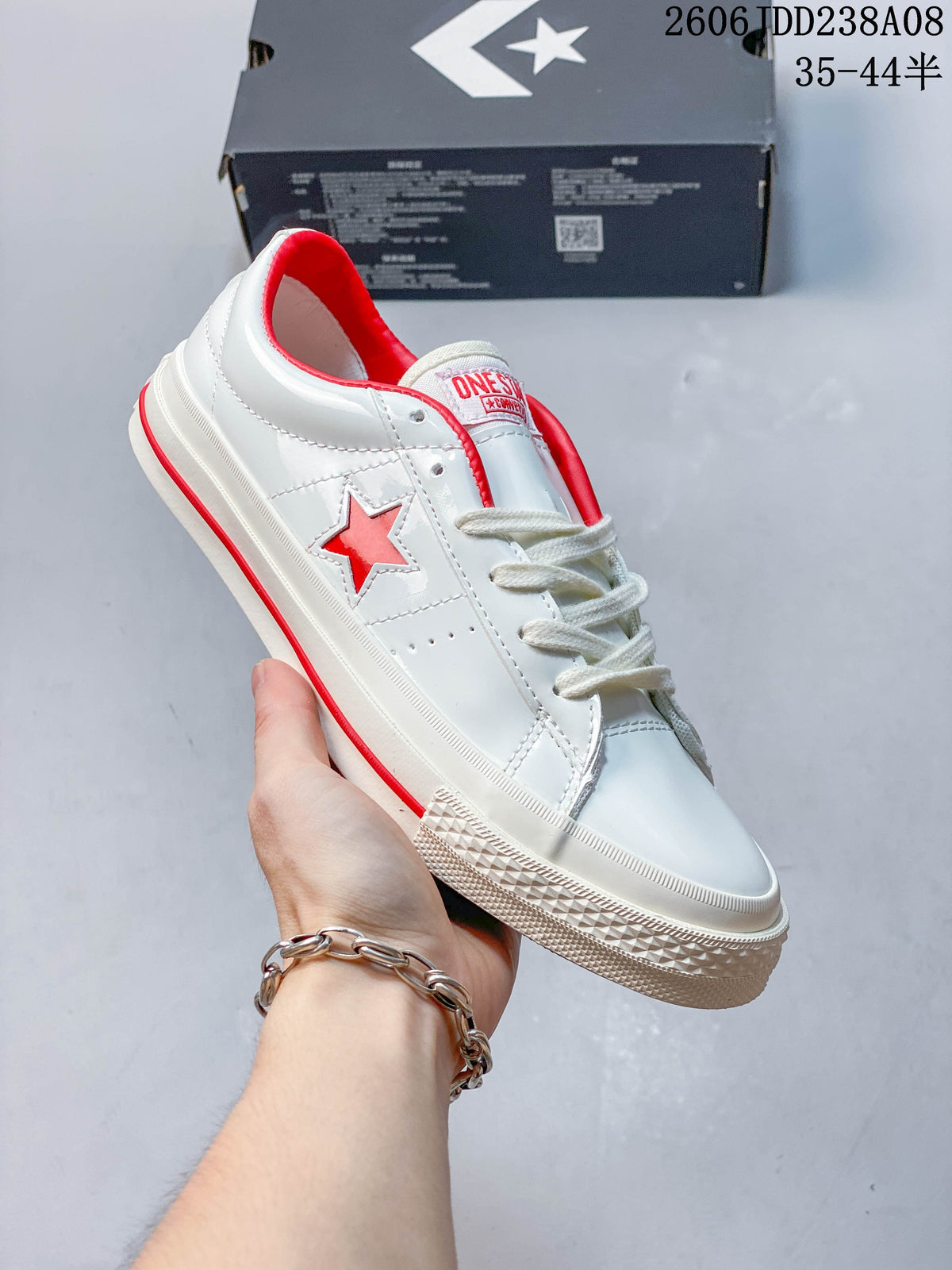 Angled side view showing the red star detail and cream-colored sole