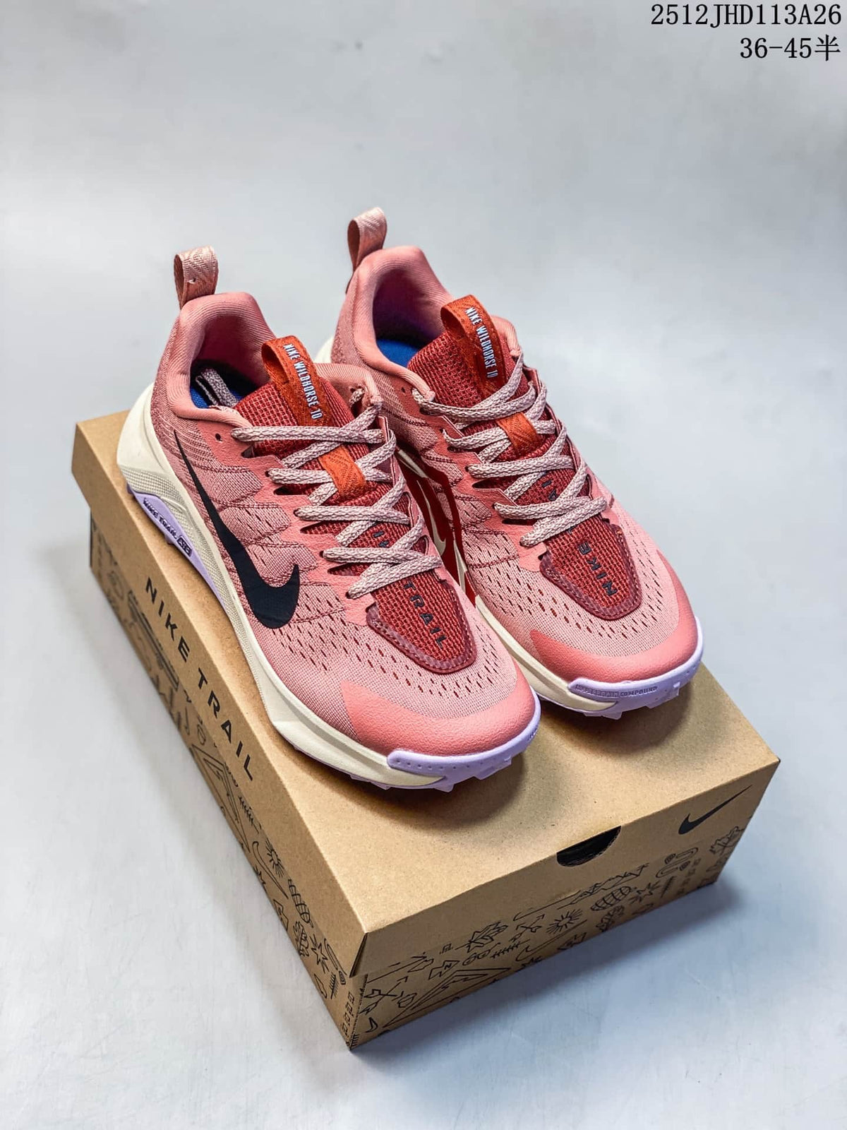 Pair of rose-pink Nike Wildhorse 10 trail running shoes displayed on a box.