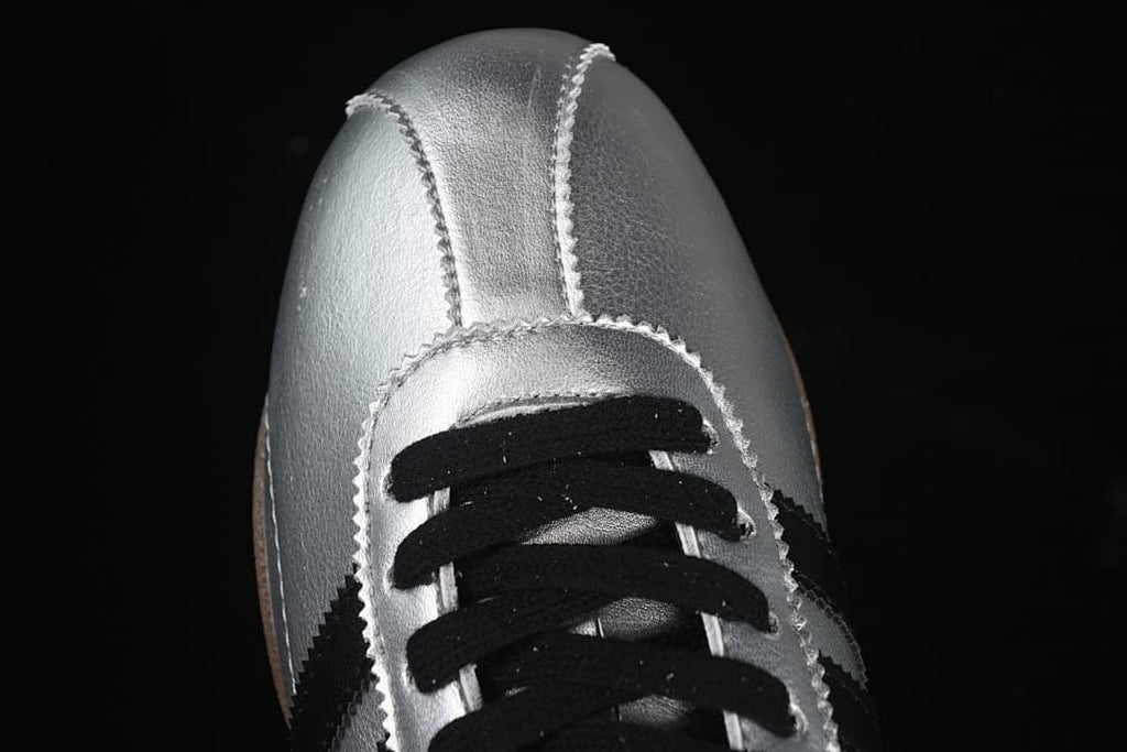 Top-front view of silver sneakers with black laces