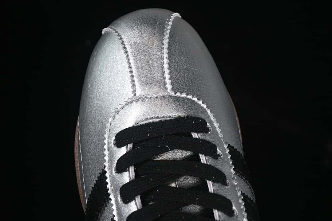 Top-front view of silver sneakers with black laces