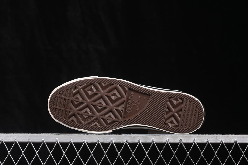 Outsole view showing the textured brown rubber tread and Converse All Star markings.
