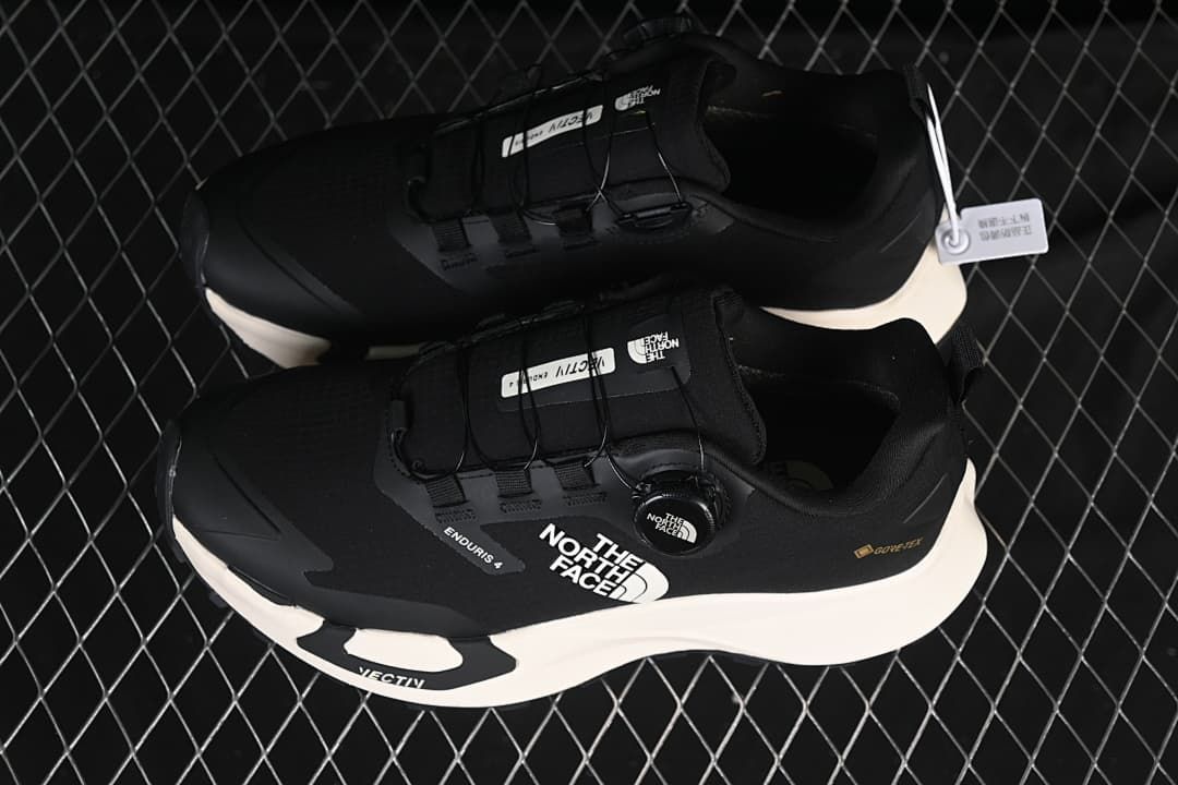 Pair of black low-cut shoes with light-colored midsoles, viewed from above.