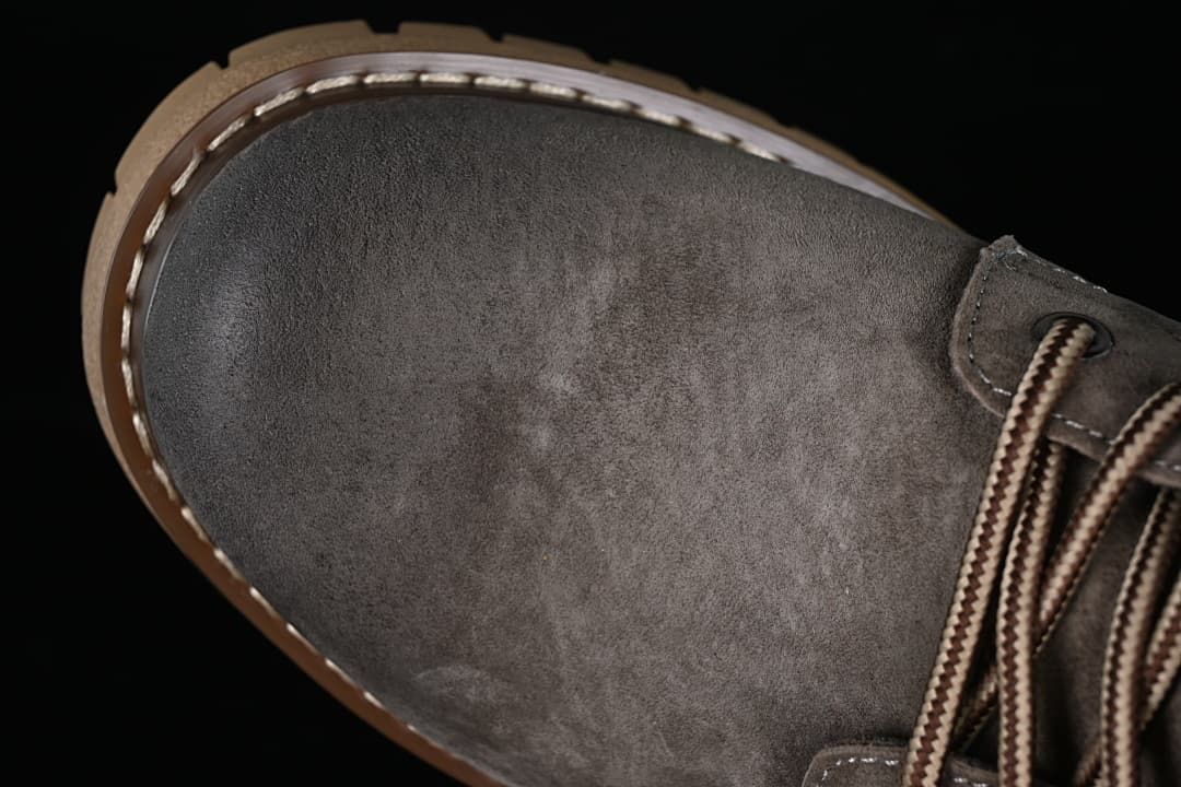 Close-up of the gray boot's rounded toe and laces.