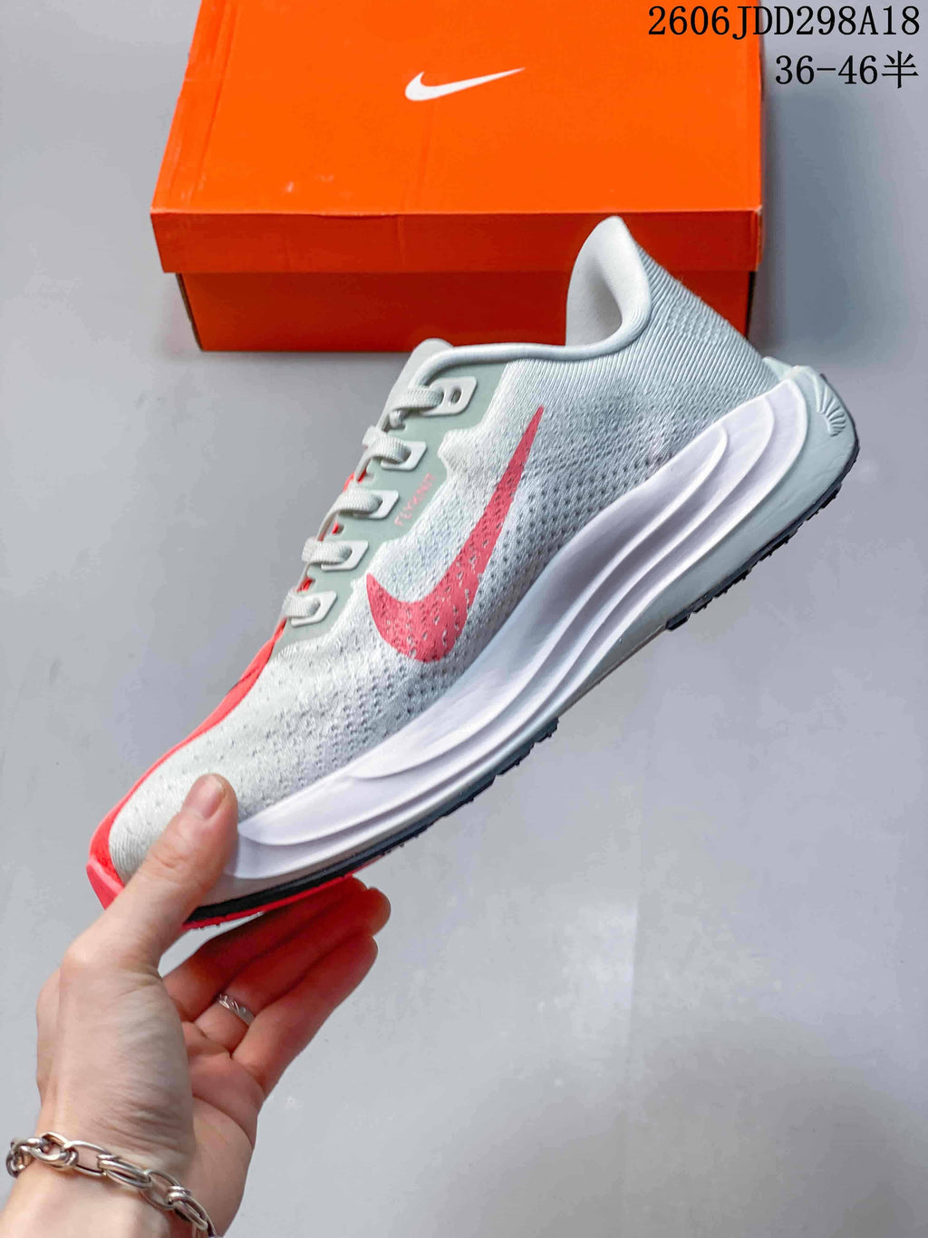 Side profile showing the gray upper, coral Swoosh, and sculpted white midsole