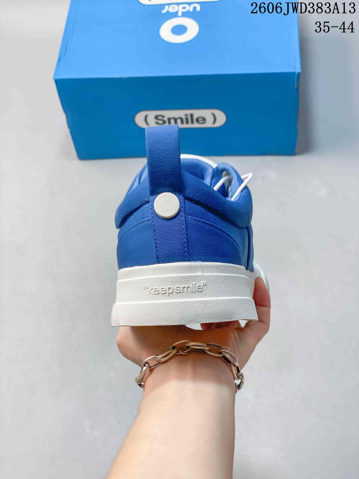 Rear view of a blue sneaker showing the heel pull loop and white sole.