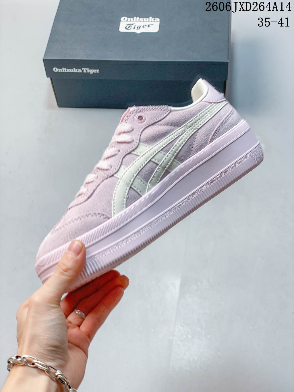 Side view of the pale pink sneaker with ivory stripes and a raised sole