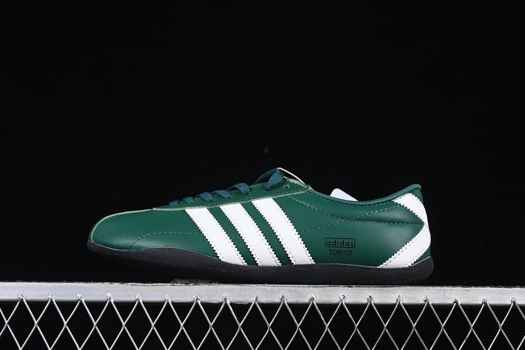 Side view of a dark green adidas Tokyo sneaker with white stripes and a black sole.
