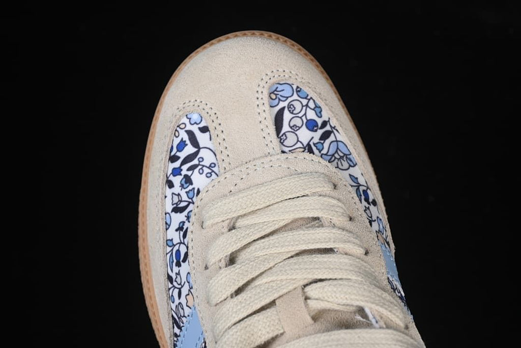 Top-down detail of the cream toe overlay, laces, and floral-print panels