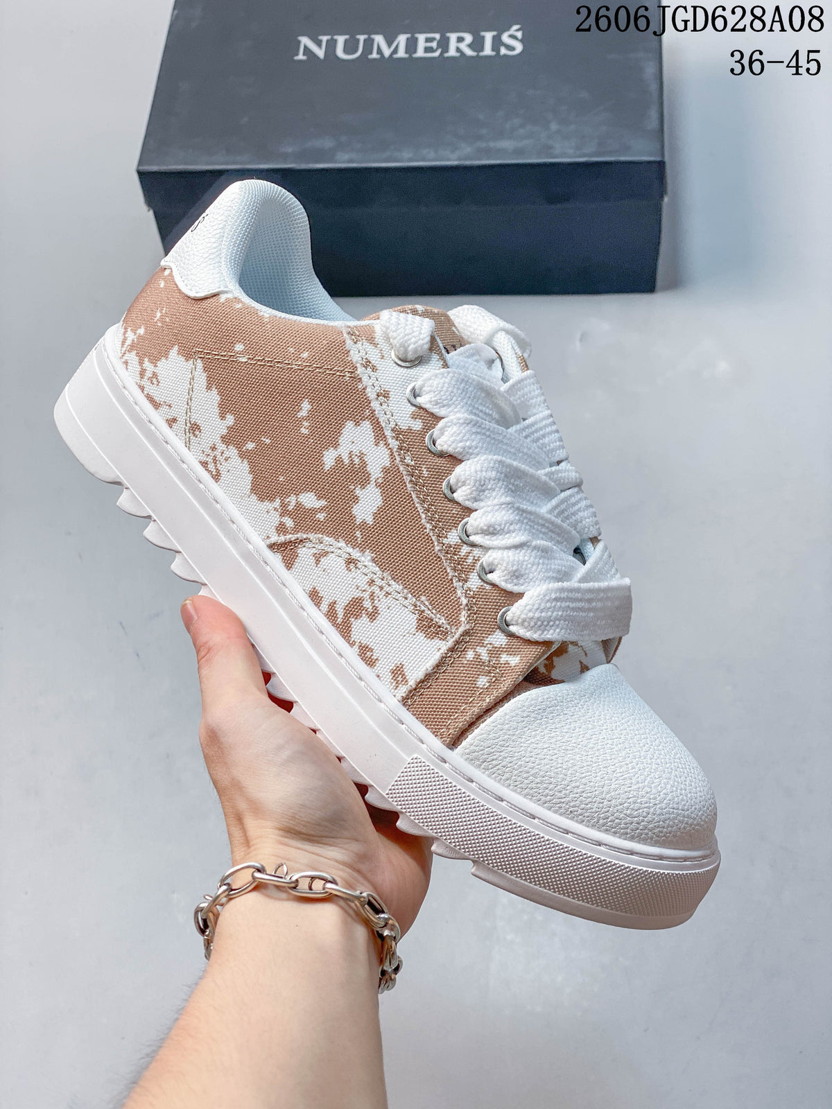 Tan-and-white Numeris low-top sneaker with an abstract printed side panel.