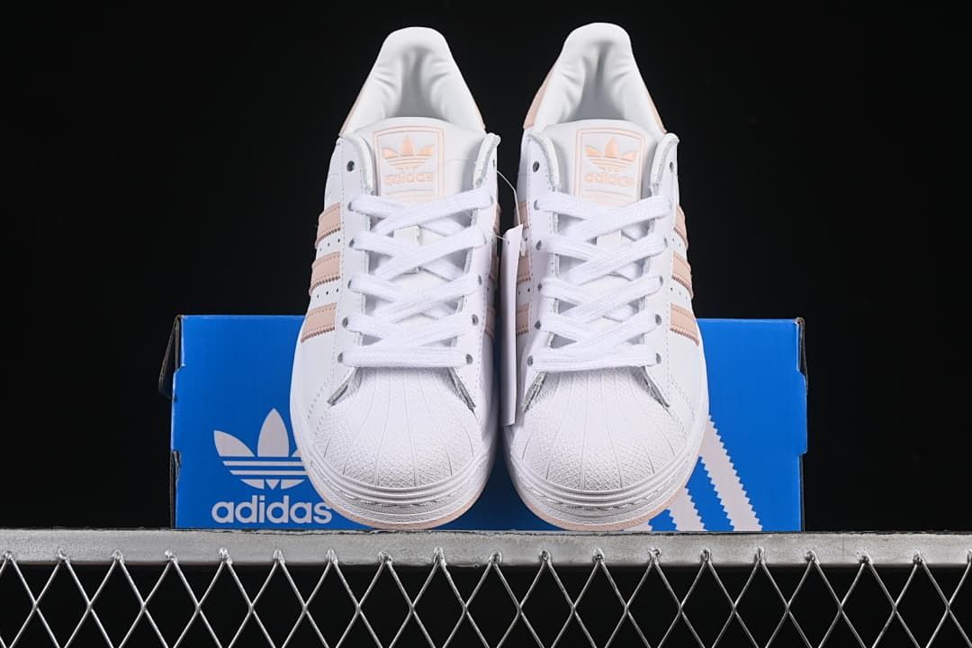 Front view of the pair of white Superstar sneakers displayed on the box.