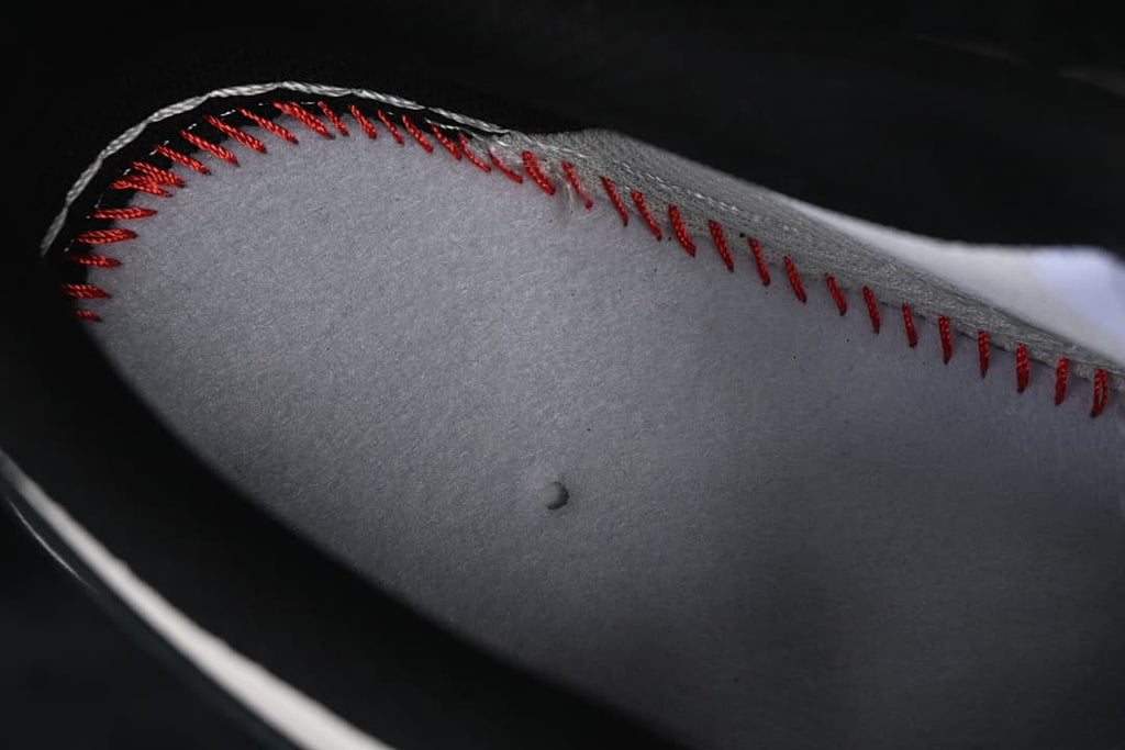 Close-up of grey material with red stitching.