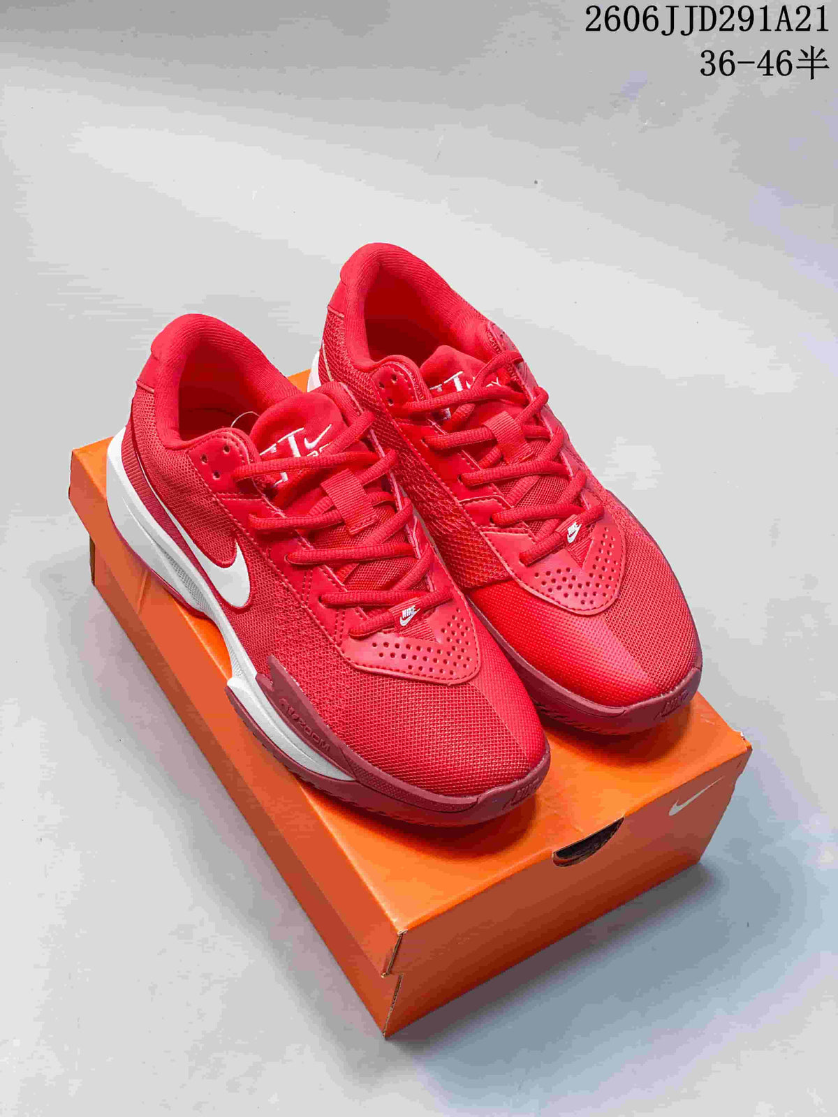 Pair of red Nike G.T. Cut basketball shoes with white accents on an orange shoe box.