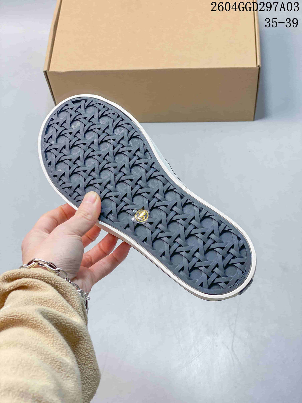 Underside of the sneaker showing a dark patterned outsole