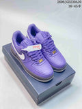 Pair of purple Nike Air Force 1 low-top sneakers with white Swooshes and gray midsoles