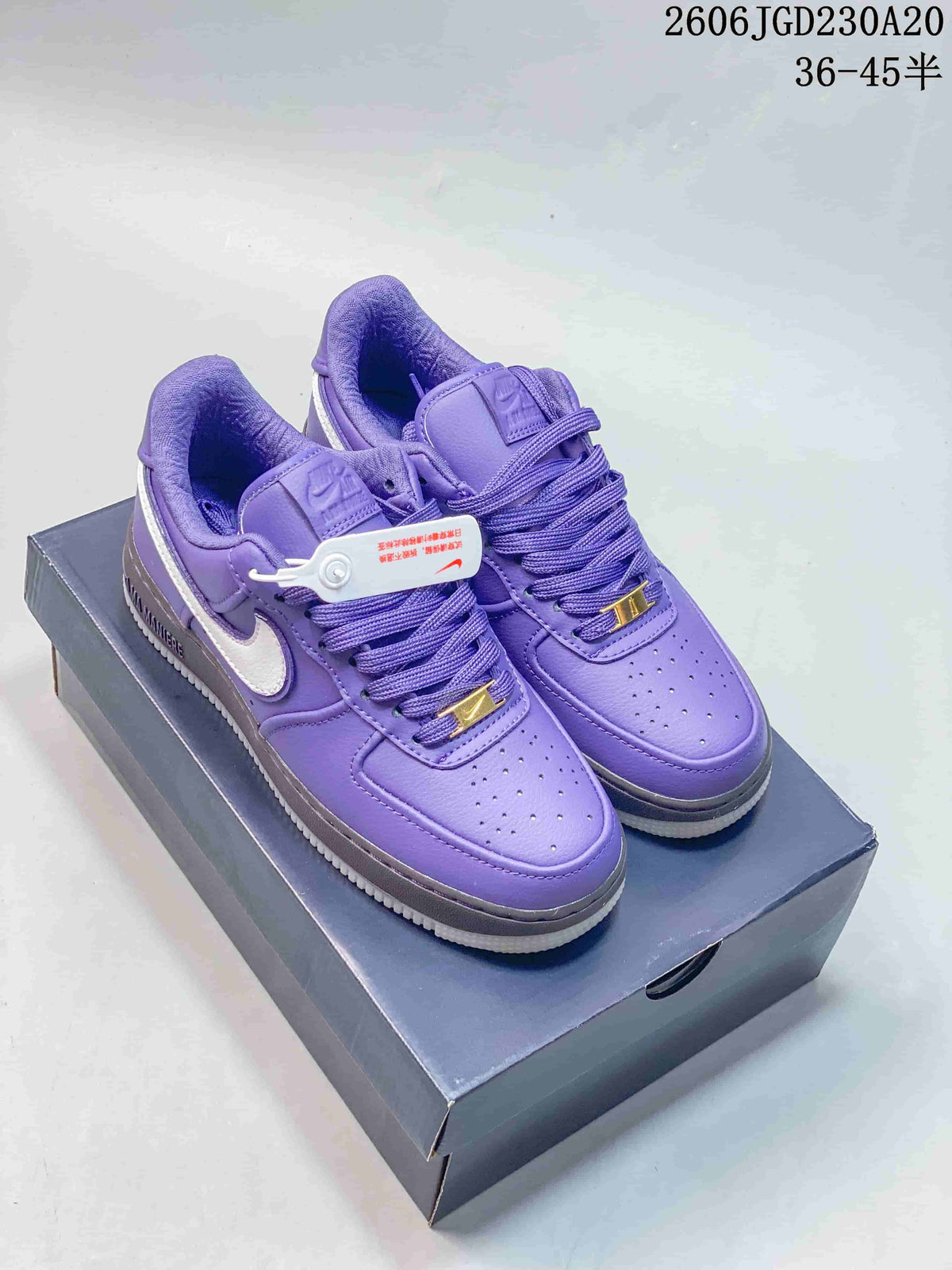 Pair of purple Nike Air Force 1 low-top sneakers with white Swooshes and gray midsoles
