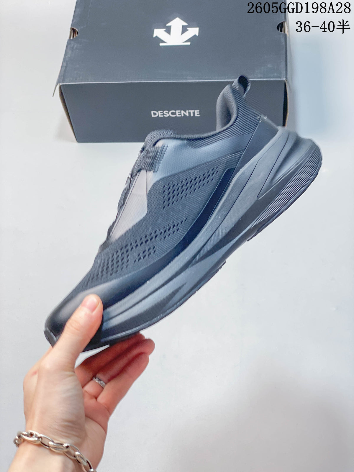 Side profile showing the thick sole of a gray DESCENTE shoe