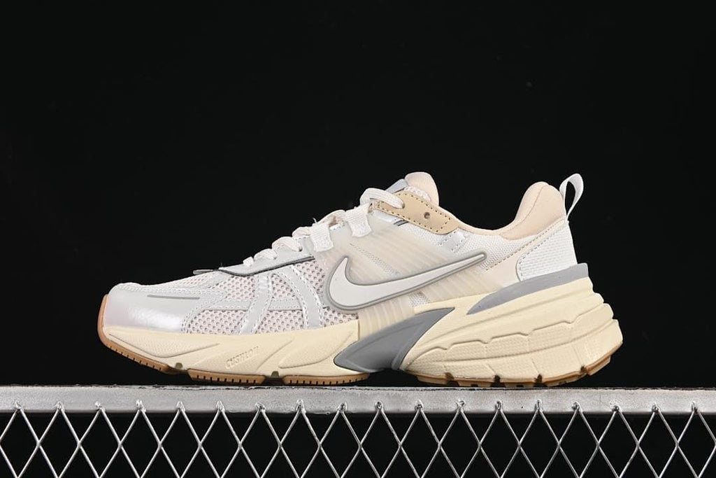 Side view of a light-colored Nike V2K Run Tekk low-top sneaker with gray accents