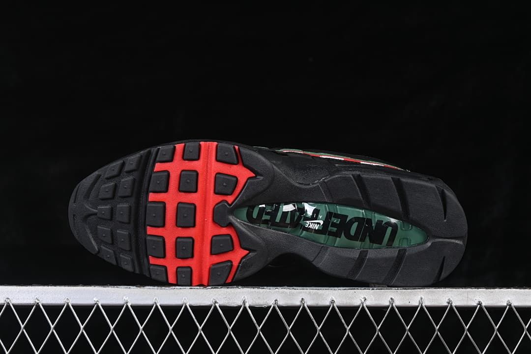 Outsole view with black tread, red accents, and a green center window