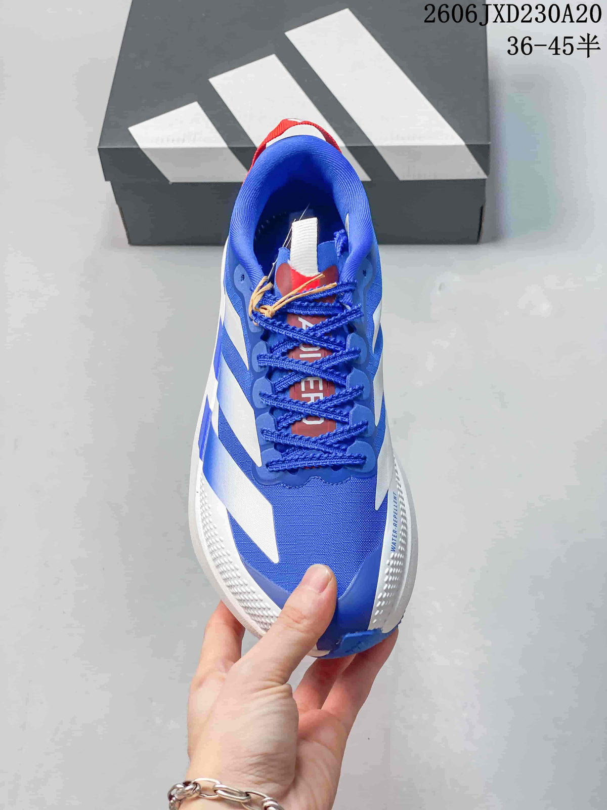 Top view of a blue Adidas running shoe with blue laces and red details