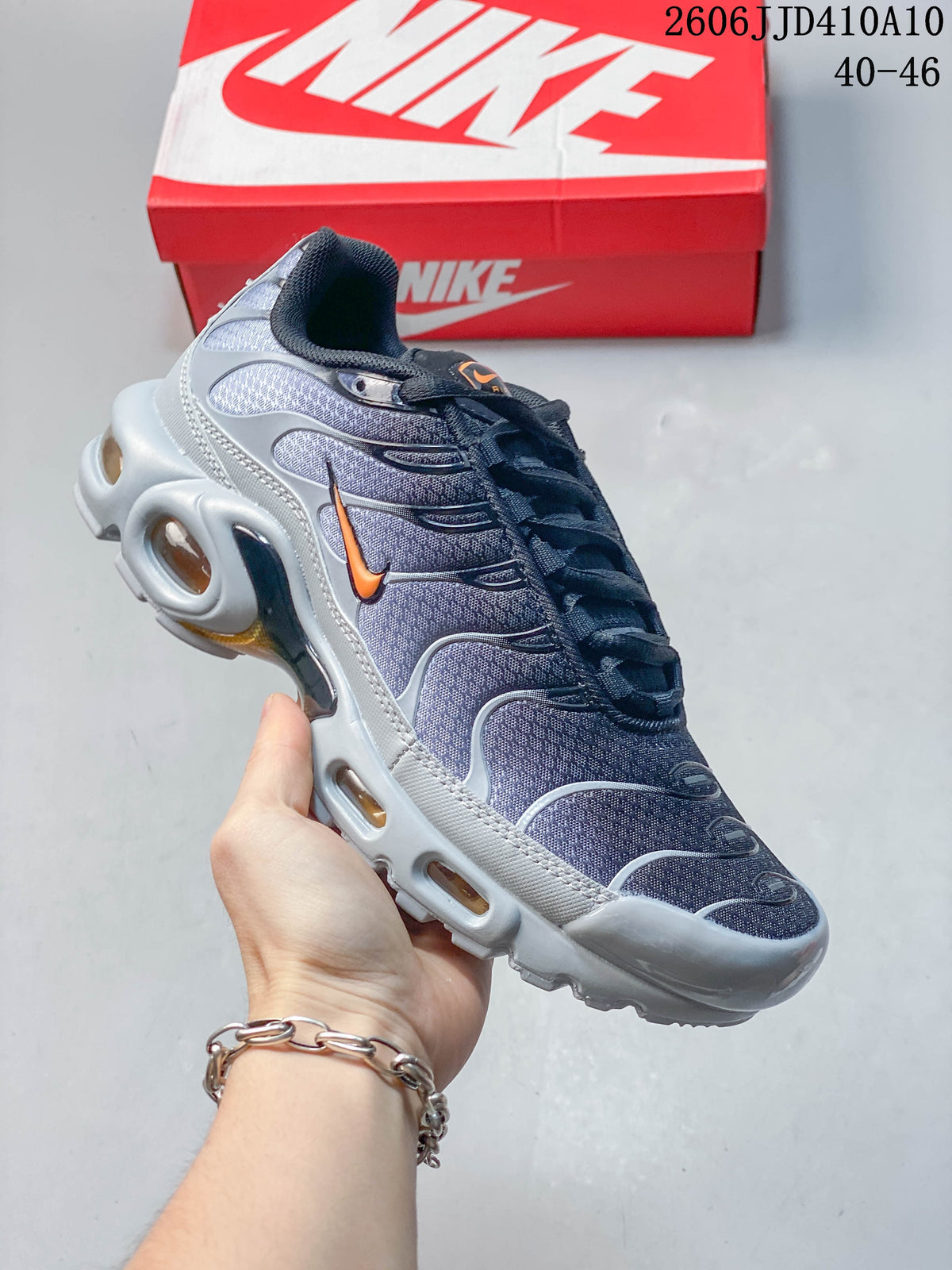 Dark gray Nike Air Max 95 sneaker with orange accents shown from the side.