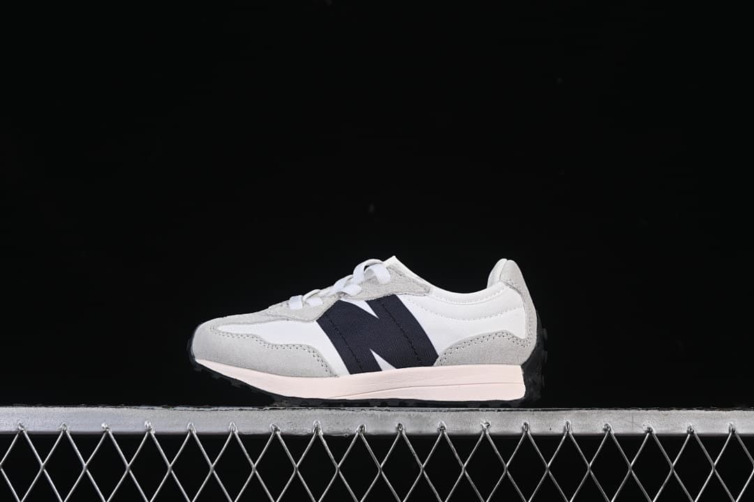 Side view of a white and light gray New Balance 327 kids’ sneaker with a navy side accent.