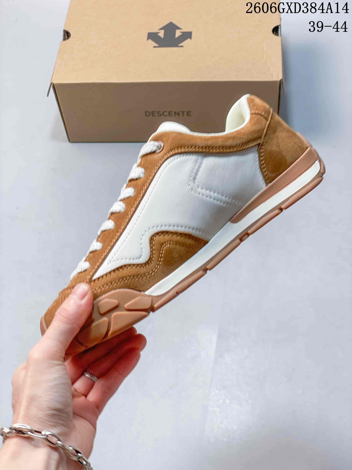 Side profile showing brown and white panels on a Descente sneaker