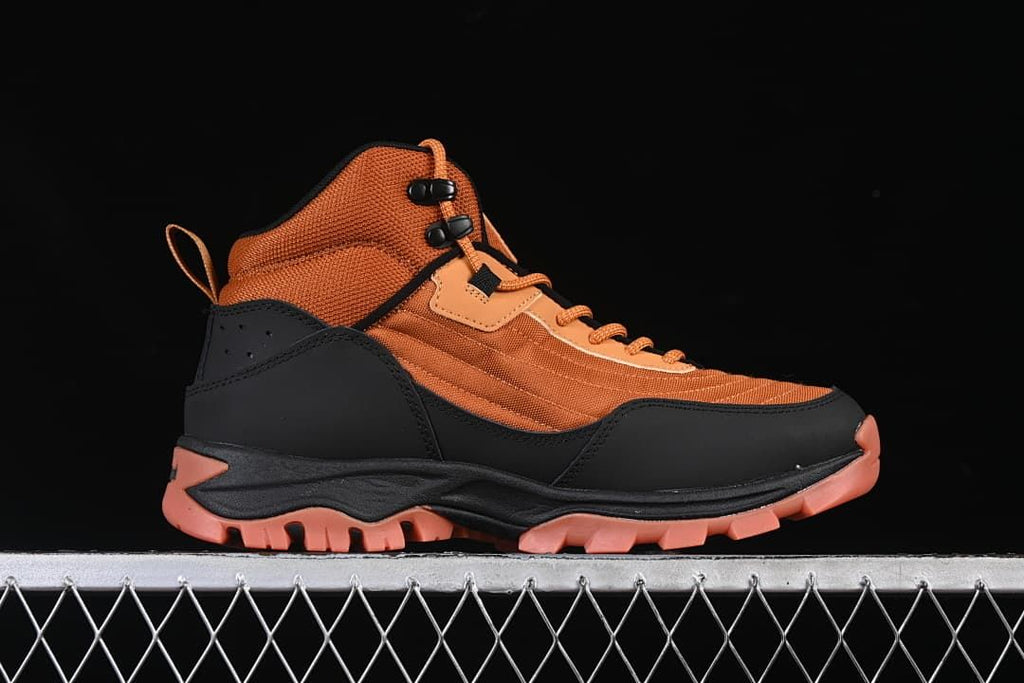 Side profile of an orange and black mid hiking boot