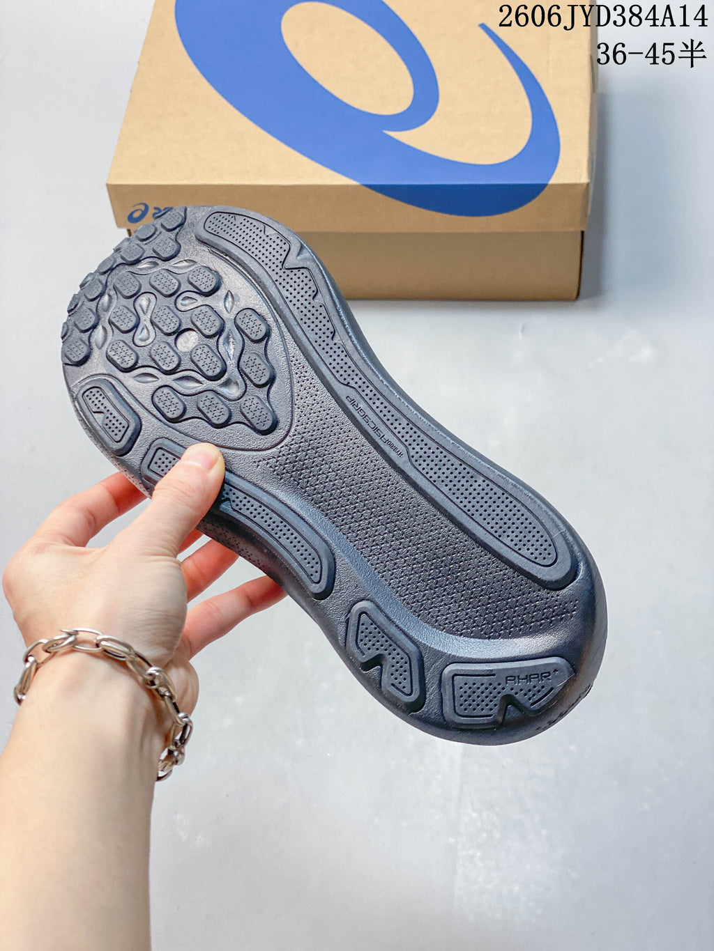 Close-up of the patterned outsole of a dark-colored running shoe