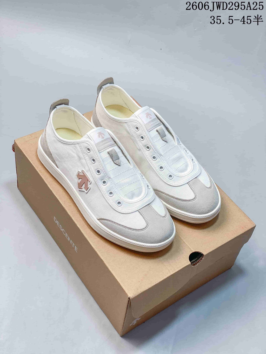 White and gray DESCENTE CHRON sneakers displayed on a shoebox