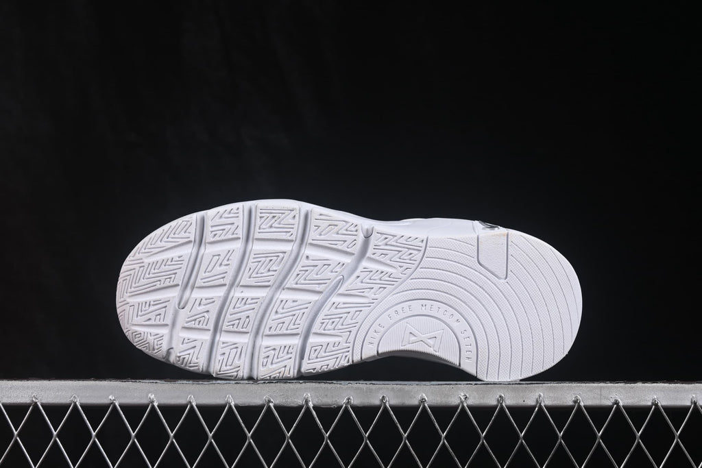 Outsole view showing the segmented tread pattern and molded sole design of the white sneakers.