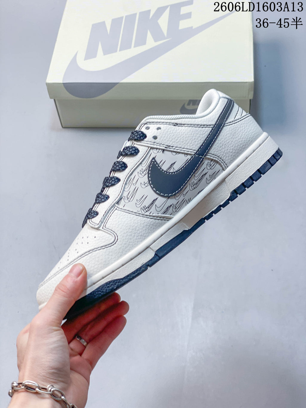 Side view of the cream sneaker with navy accents and patterned panels.