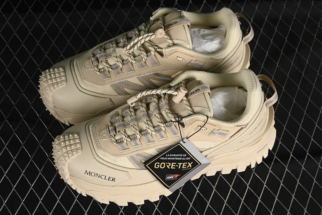 Pair of beige Trailgrip GTX sneakers with a hangtag.
